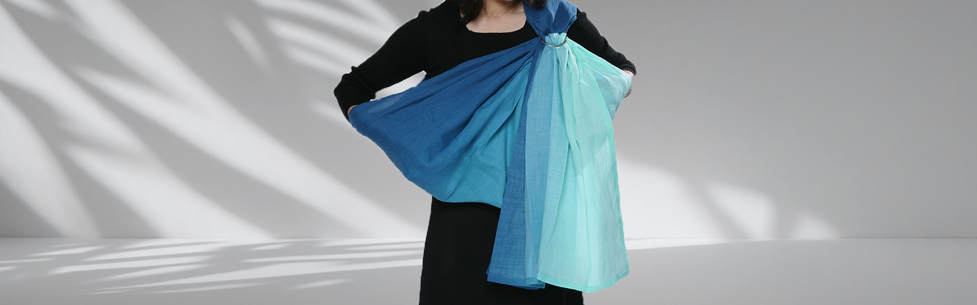 A mother holding her baby in a PsLing baby sling, illustrating the Art of Holding