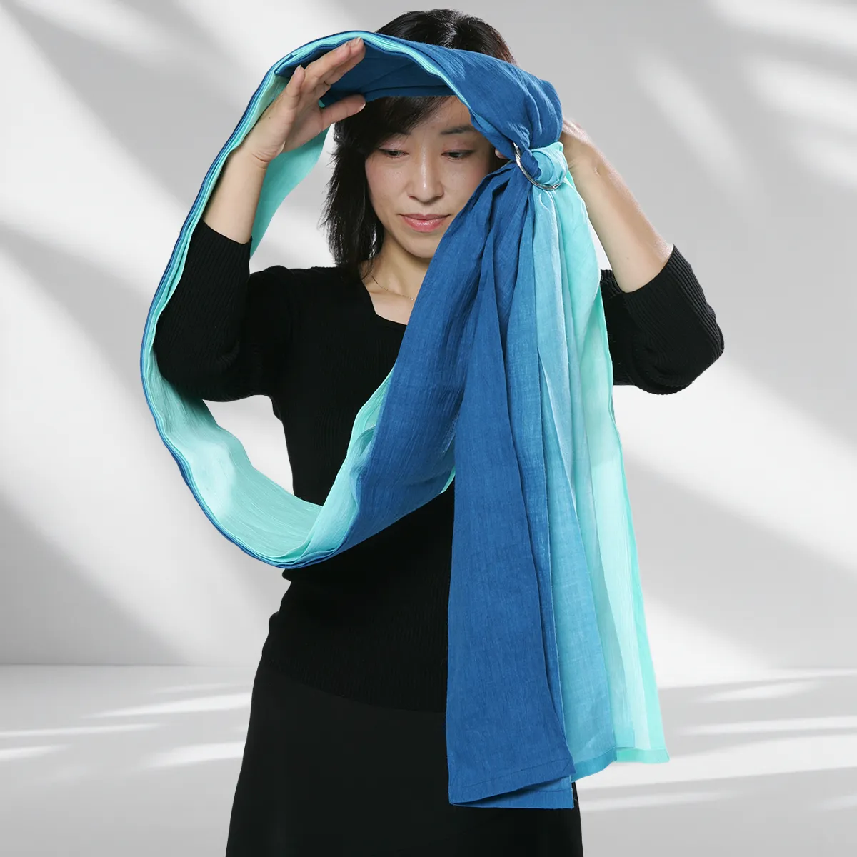Step 06: Draping the Sash. Raise your arm and guide your head through the sling. Wear it diagonally across your torso like a sash, ensuring the rings sit high and the tail hangs forward.